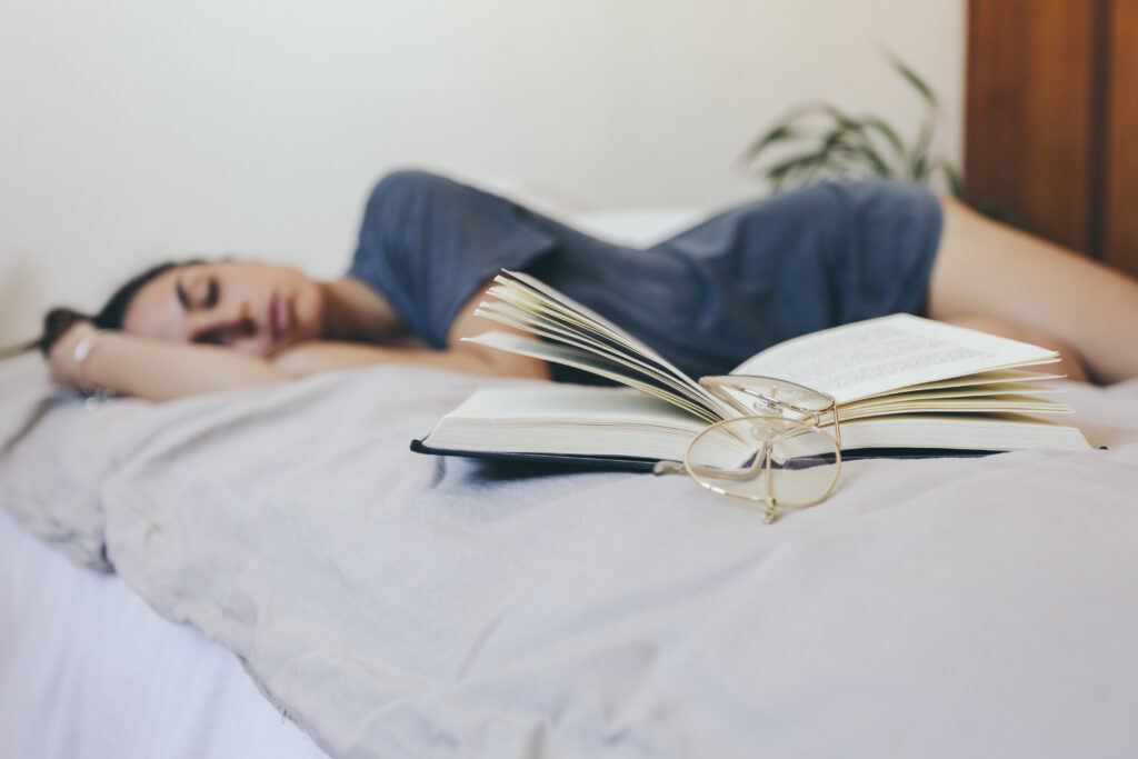 glasses-book-near-sleeping-woman